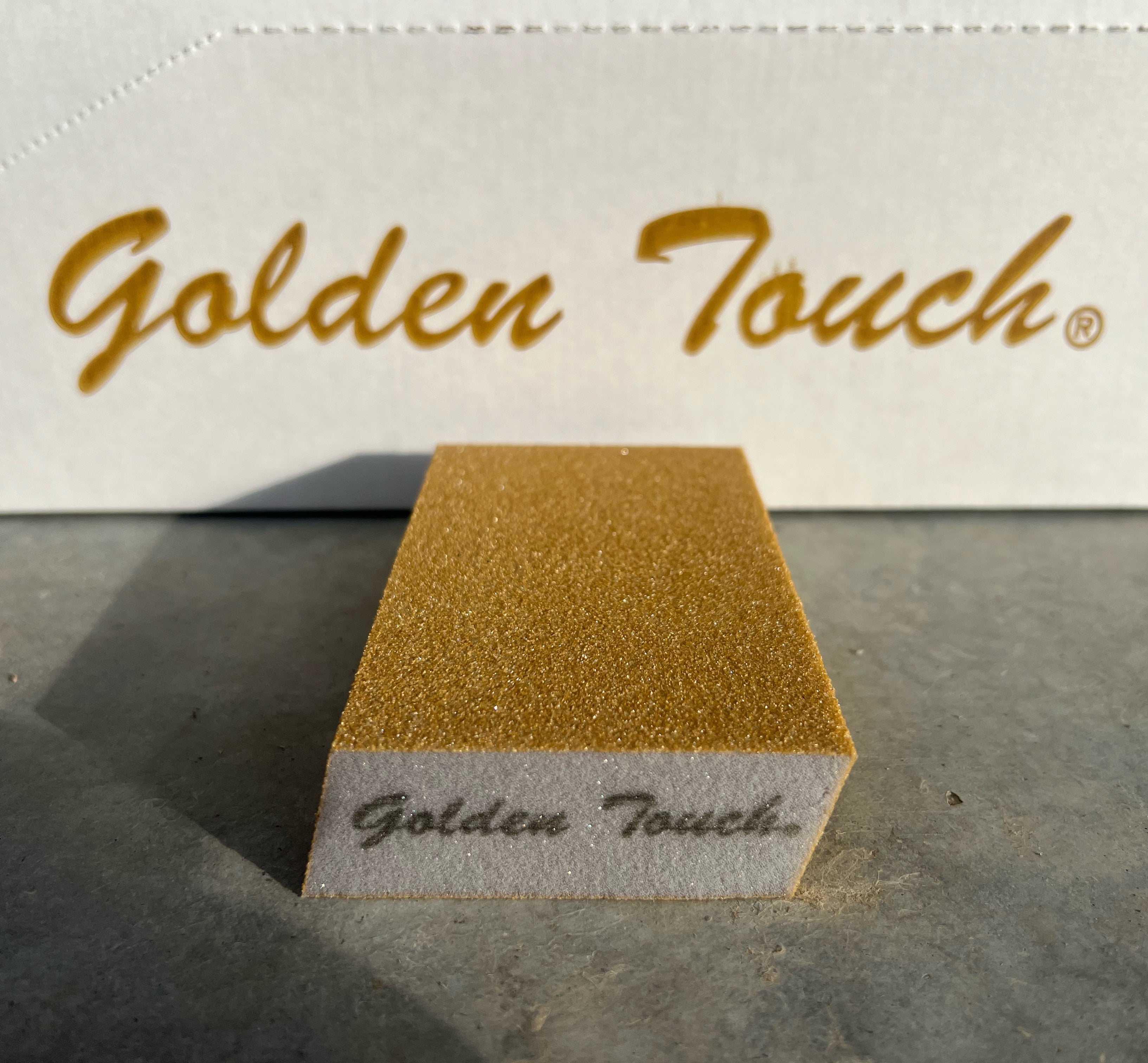 Gold sanding block with 'Golden Touch' branding on a textured surface.